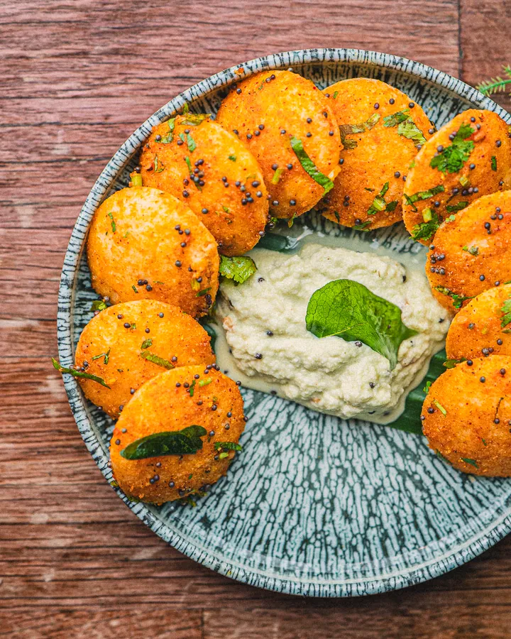 Small idlies dusted with podi, round a bowl of coconut chutney